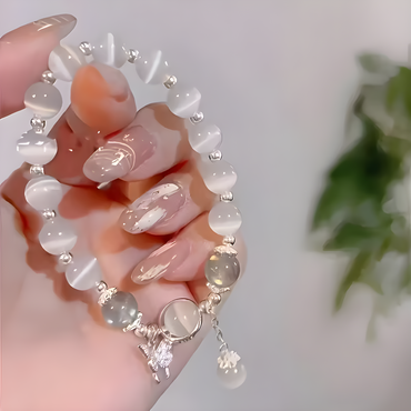Elegant armband med månstenspärlor i glas och fjärilsberlock